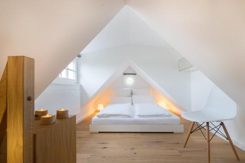 a bedroom with a white bed in a attic at Lütthüs Blankenese in Hamburg