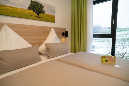 ein Schlafzimmer mit einem großen Bett und einem Fenster in der Unterkunft Hotel FÜNF10 in Netphen