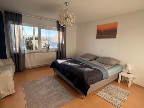 a bedroom with a bed and a chandelier at Panorama-Haus Ferienwohnung SÄNTIS - Schlafzimmer, Wohnzimmer, Küche, Bad, Sonnenterrasse mit Bergblick im Garten in Wangen im Allgäu