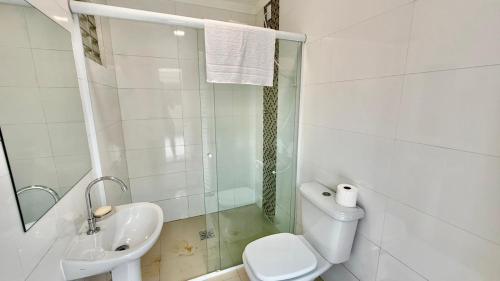 a bathroom with a toilet and a sink and a shower at Chalé 02 centro de itapema in Itapema
