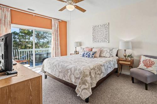 a bedroom with a bed and a tv and a window at Harbor Island 49 Nautical Watch in Fripp Island