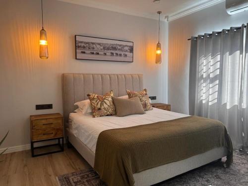 a bedroom with a large bed and a window at The Shirley in Gqeberha