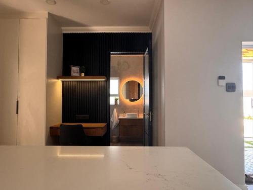 a room with a bathroom with a sink and a mirror at The Shirley in Gqeberha
