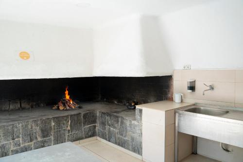 a kitchen with a brick fireplace with a fire pit at Apartamentos Tamarindos Peñiscola in Peniscola