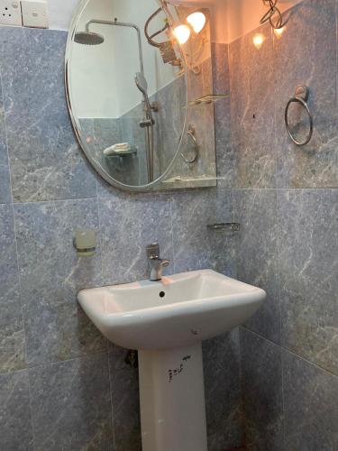 a bathroom with a sink and a mirror at TENBY Guest House in Anuradhapura