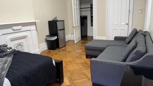 a bedroom with two beds and a couch and a fireplace at New York City Guest House 2 in New York