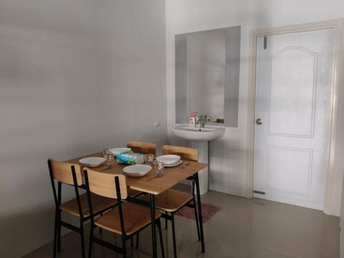 a dining room with a table and chairs and a sink at Sea heaven Phuket Naiyang in Phuket