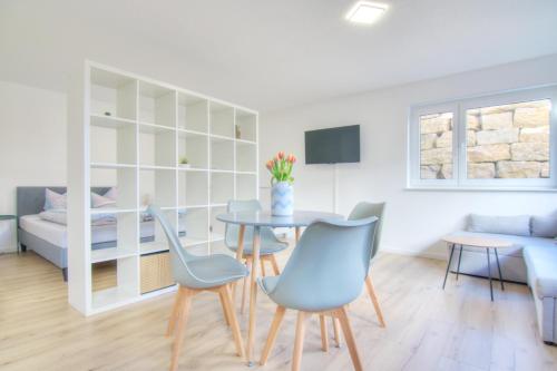 a living room with a table and chairs and a couch at Modernes Wohlfühl-Apartment mit Glasfaser-WLAN, Parkplatz in der Nähe & Küche in Bad Wimpfen in Bad Wimpfen
