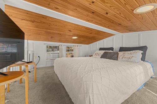 a bedroom with a bed and a wooden ceiling at Eco Luxe Tiny Cabin with Big Mountain Views in Sylva