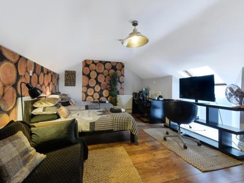 a living room with a bed and a couch and a tv at Mama’s Inn Boutique Guest House in Nottingham