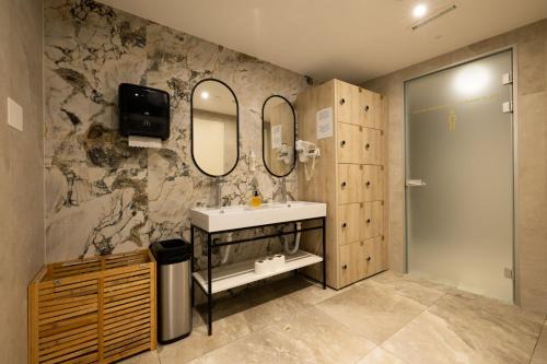 a bathroom with a sink and two mirrors at Royal Neptun Hotel in Dubrovnik
