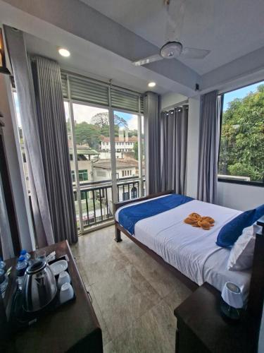 a hotel room with a bed and a large window at Kandy City Inn in Kandy