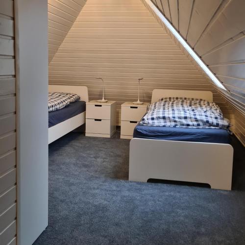 a room with two beds and two night stands at Nordseewohnung Strandloeper in Wittmund