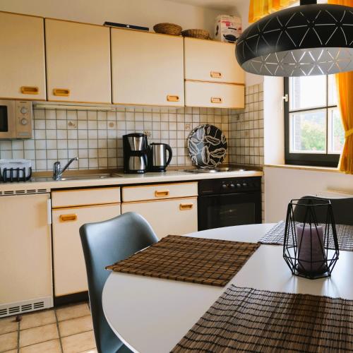 a kitchen with a table with chairs and a stove at Nordseewohnung Strandloeper in Wittmund