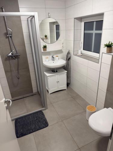 a bathroom with a shower and a sink and a toilet at Ferienwohnung Kurze Auszeit 24 Std Check in in Hesel
