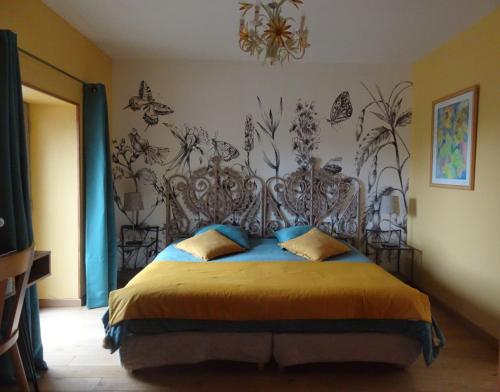 a bedroom with a bed with a metal headboard at B&B La Maison Des Collines Autour Chambres d'hôtes in La Chapelle