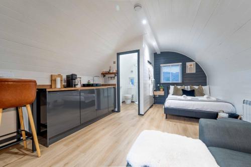 a bedroom with a bed and a kitchen in a room at Apex Studio Pod and Jacuzzi Bath in Fort William