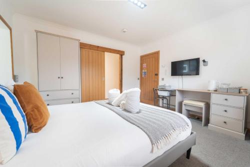 a bedroom with a white bed and a desk at Ben View Room and Jacuzzi Bath in Fort William