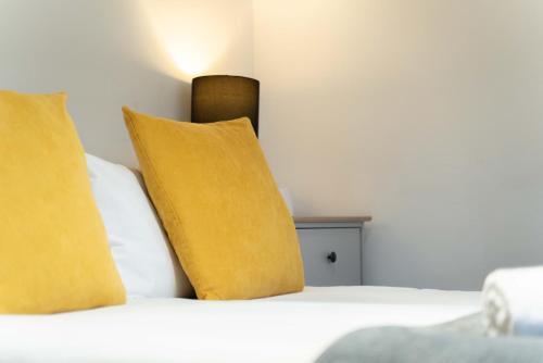 a bed with two pillows and a yellow pillow at Ben View Room 4 in Fort William