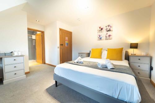a bedroom with a large bed with yellow pillows at Ben View Room 4 in Fort William