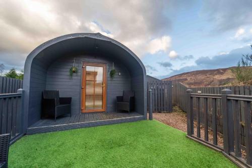 a gazebo with two chairs in a yard at Ben View Pod and Jacuzzi Bath in Fort William