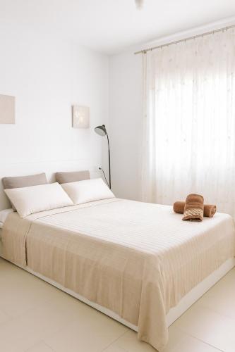 a white bedroom with a large bed with white sheets at Can Angelica in Santa Margalida