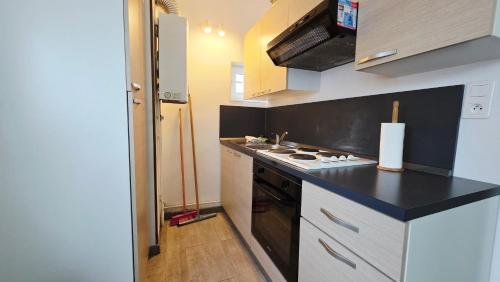 una cucina con fornelli e piano di lavoro nero di Studio Foch 3 a Grand-Fort-Philippe