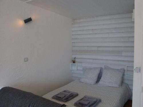 a bedroom with a bed with two pillows on it at Les Epinettes Studio Prairie in Gérardmer