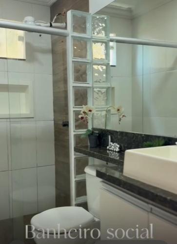a bathroom with a white toilet and a sink at Casa de temporada em Jacaraípe in Serra