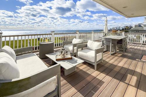 a deck with a couch and a table and chairs at Pine Creek Beach House in Fairfield