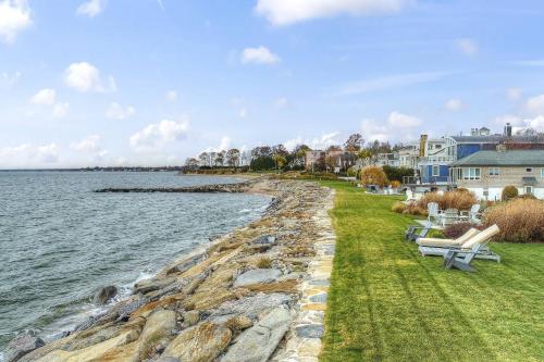 a shoreline with benches and houses and the water at Pine Creek Beach House in Fairfield