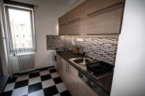 cocina con fregadero y suelo a cuadros en blanco y negro en Deák design apartment, en Budapest