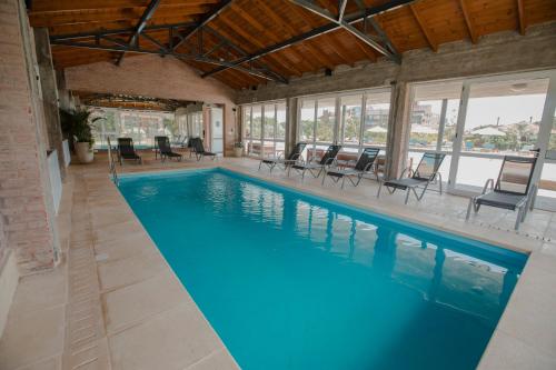 a large swimming pool with chairs and tables at Il Belvedere in Punta del Este