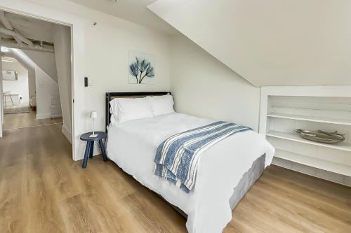 a white bedroom with a large bed and a staircase at Harbor Haven, Apt #4 - 2BR/1BA in Stamford