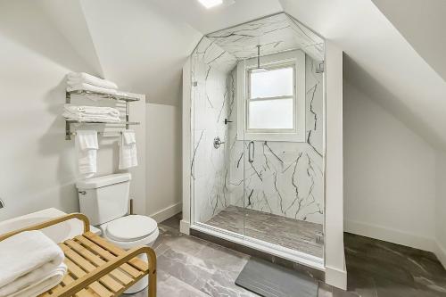 a bathroom with a shower with a toilet and a window at Harbor Haven, Apt #4 - 2BR/1BA in Stamford