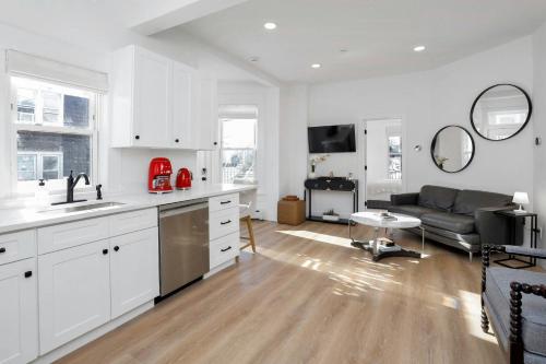 a kitchen and living room with white cabinets and a couch at Harbor Haven, Apt #5, 3BR/2BA in Stamford