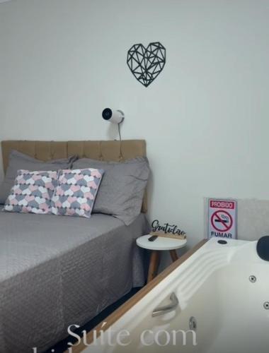 a bedroom with a bed and a side table at Casa de temporada em Jacaraípe in Serra