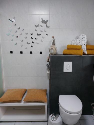 a bathroom with a toilet and butterflies on the wall at Gemütliches Feriendomizil in Niederorschel