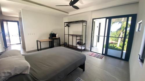 a bedroom with a bed and a large window at Casa Kimara in Uvita