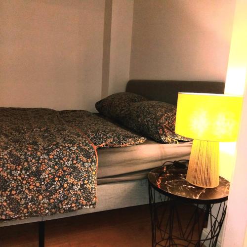 a bedroom with a bed and a lamp on a table at Klonowicza One in Leszno