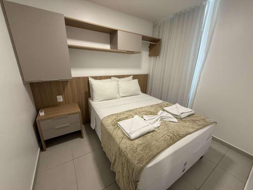 a small bedroom with a bed with two towels on it at Sunny Hall by AFT in Porto De Galinhas
