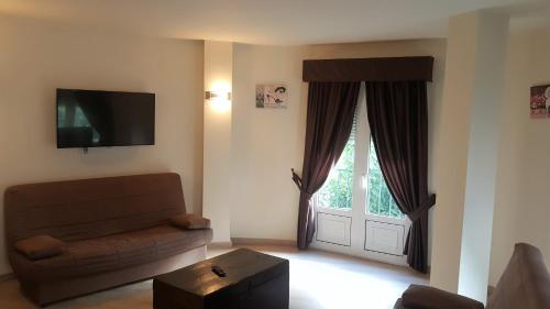 a living room with a couch and a window at Hotel El Pozo in Torremolinos