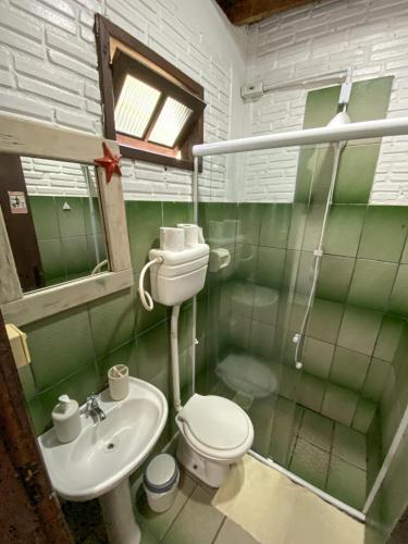 a bathroom with a toilet and a sink at Pousada Vale da Praia in Praia do Rosa