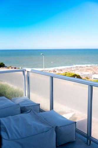 a balcony with blue chairs and the ocean at LazyYzer in Yzerfontein