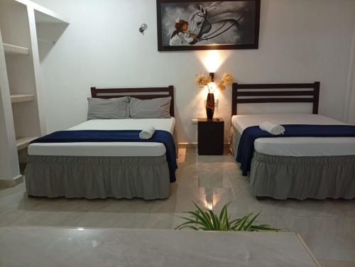 a bedroom with two beds with blue sheets at Habitaciones Aurelia in Felipe Carrillo Puerto