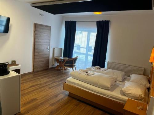 a bedroom with a bed and a table and a window at Rohrbacher Herz in Rohrbach in Oberösterreich