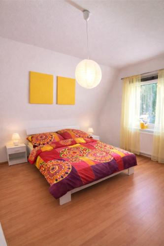a bedroom with a bed with a colorful comforter at Fuchs & Hase im "Frau-Holle-Land" in Nentershausen