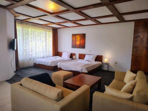 a hotel room with two beds and a living room at Homely in Bansko