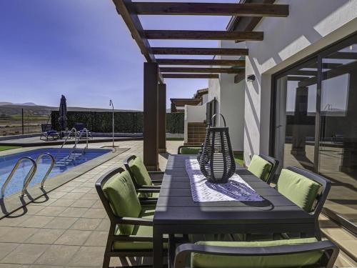 a table and chairs on a patio next to a pool at GuestReady - Luxury Villa with Pool in Antigua