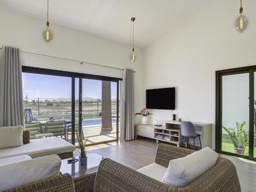 a living room with a couch and a tv at GuestReady - Luxury Villa with Pool in Antigua